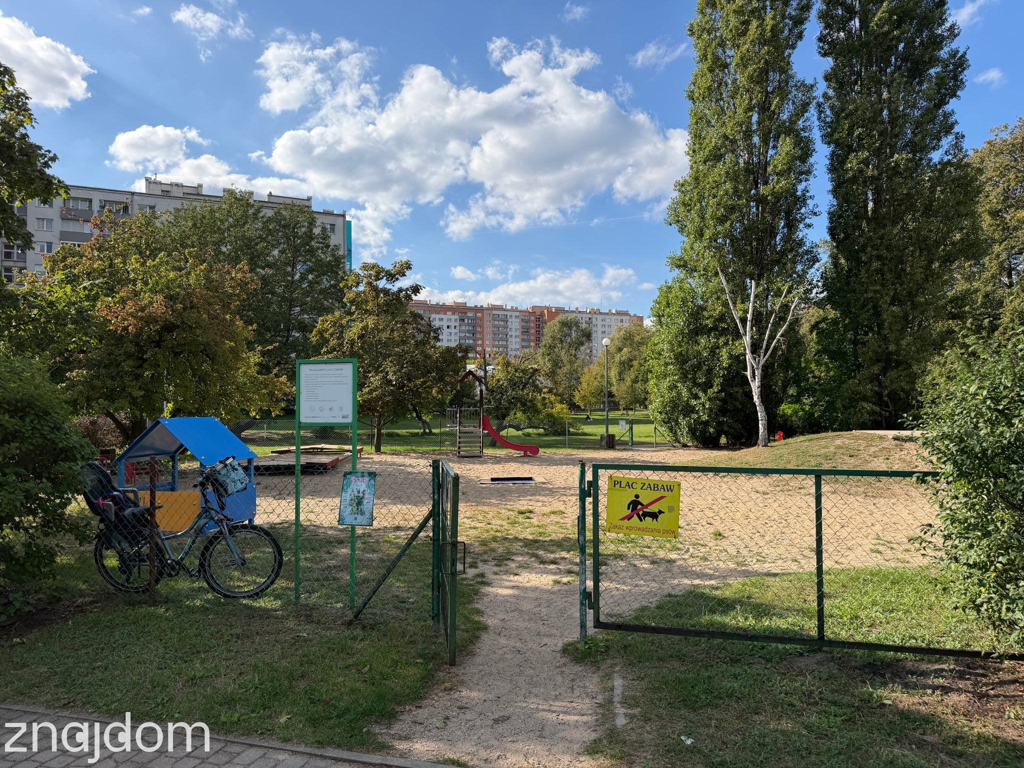 Bielany: plac zabaw na osiedlu, za jego płotem zostawiony rower.
