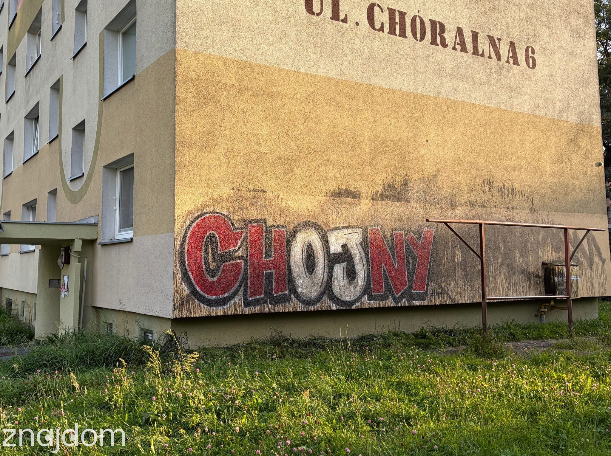 Napis graffiti Chojny na elewacji bloku z wielkiej płyty przy ulicy Choralnej w Łodzi