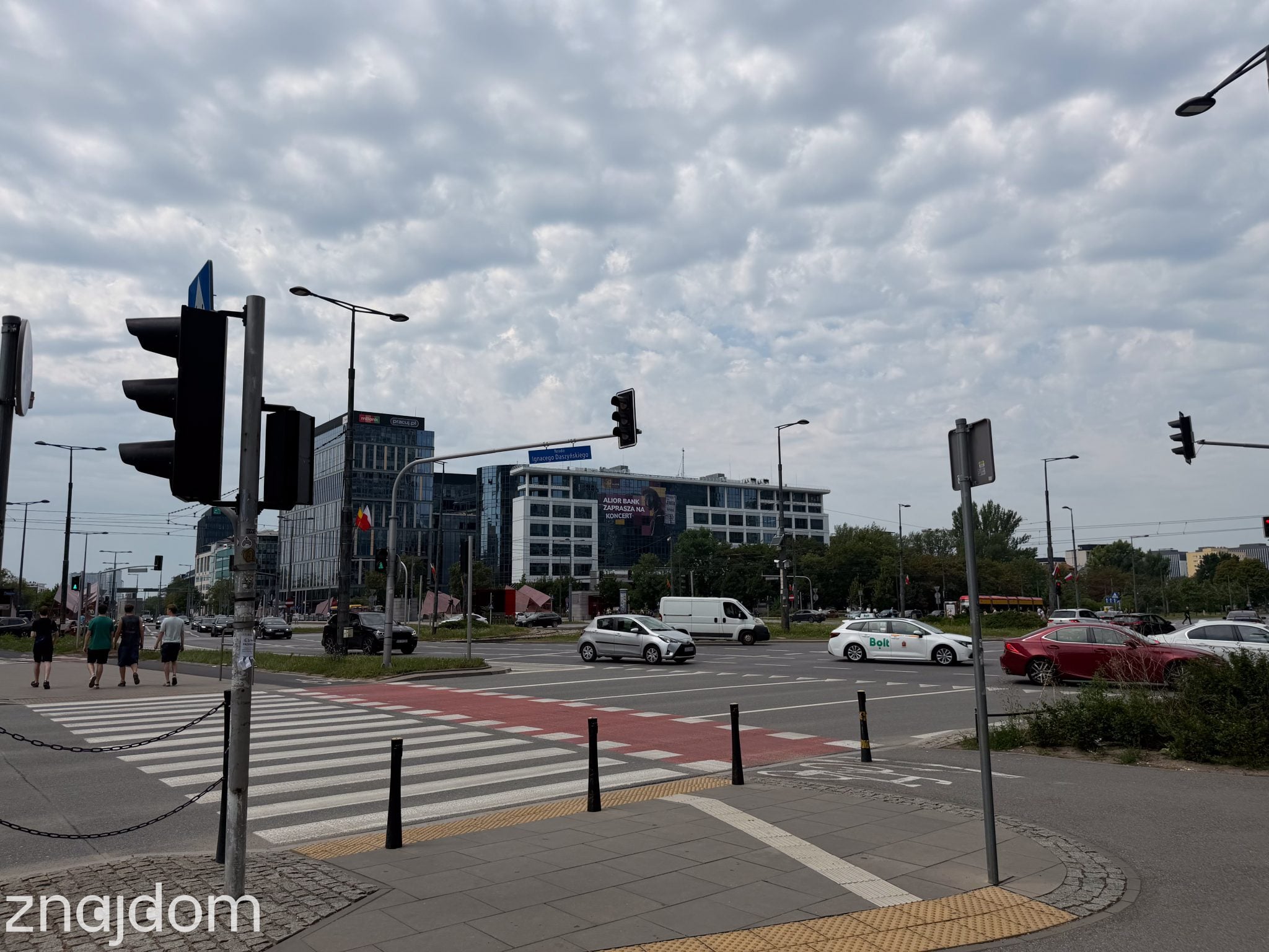 Widok na Rondo Daszyńskiego w Warszawie: samochody, sygnalizatory świetlne i biurowce w tle.