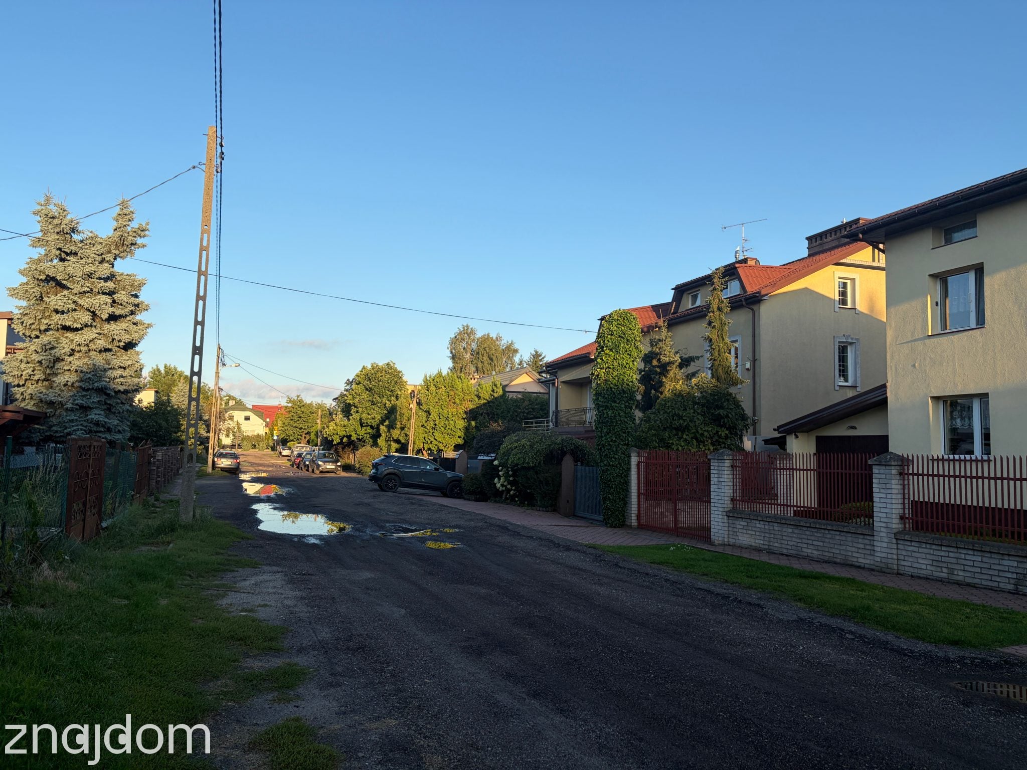 Domki przy drodze gruntowej z kałużami. Łódź Stoki.