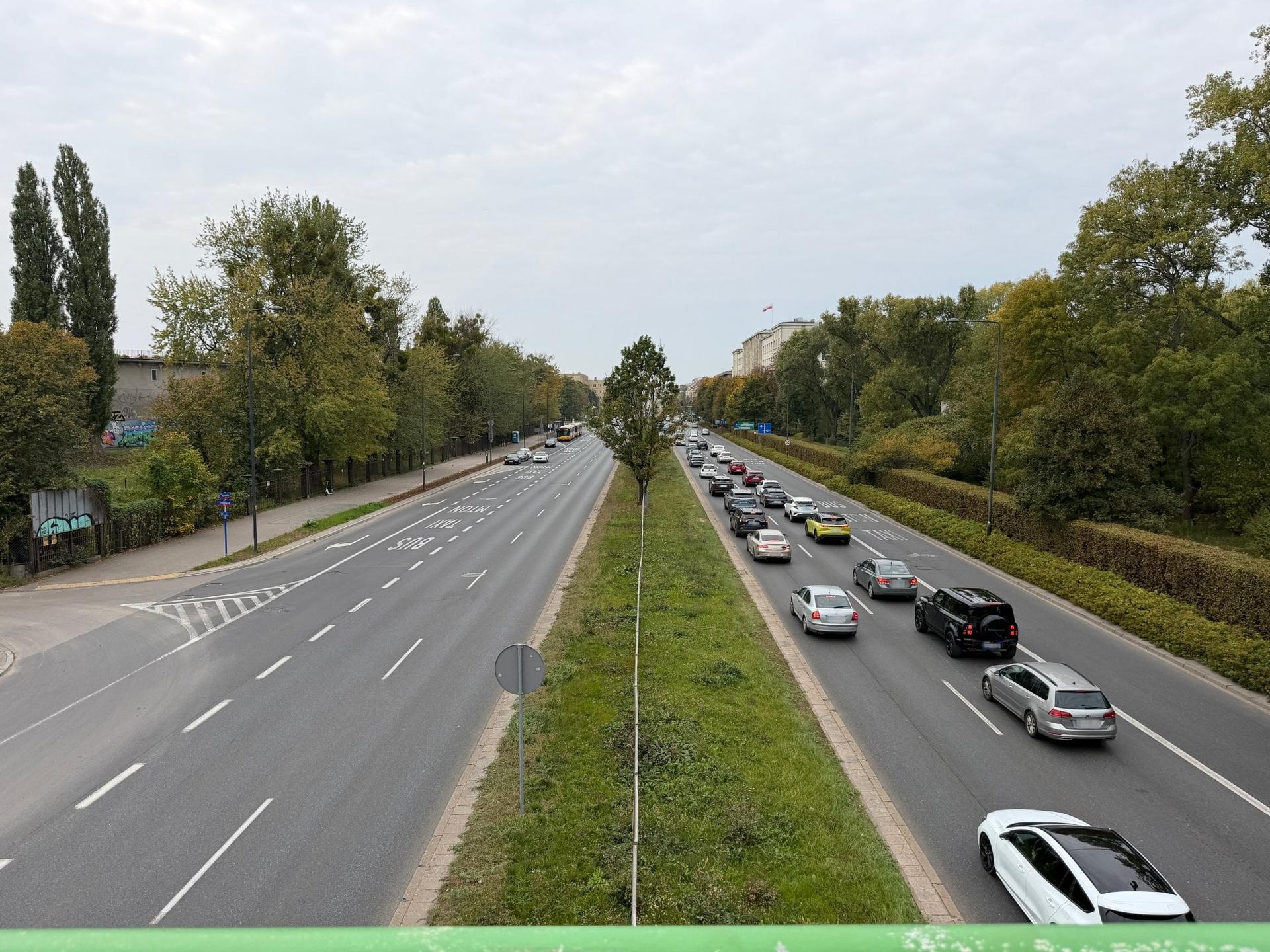 Ul. Wawelska na Ochocie: dwie drogi trzyjezdniowe rozdzielone pasem zieleni.