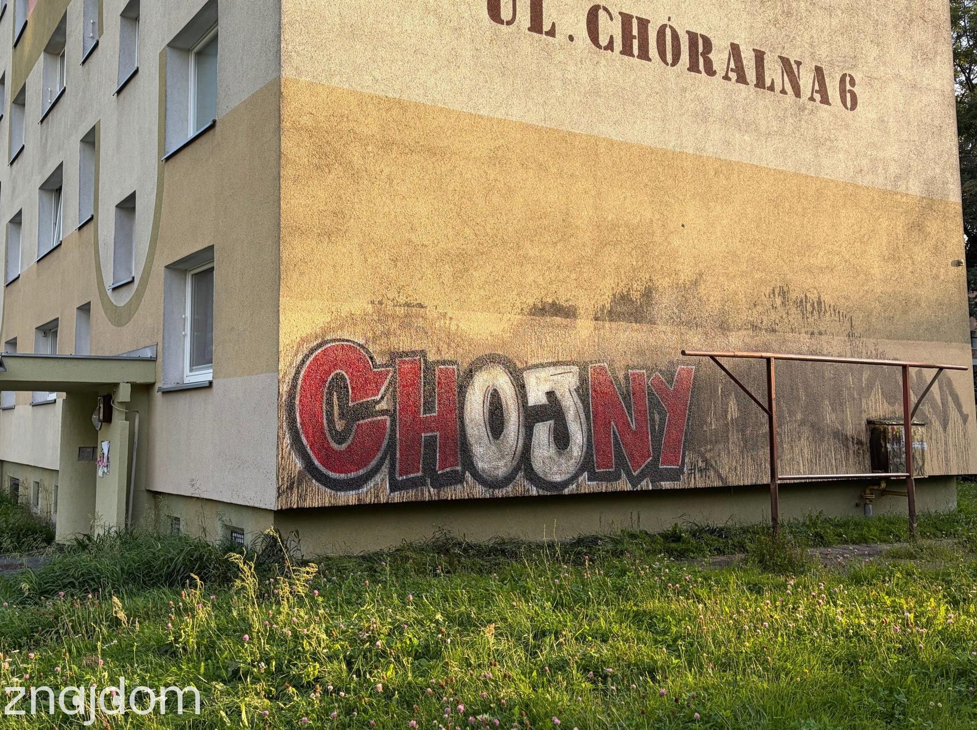 Napis graffiti Chojny na elewacji bloku z wielkiej płyty przy ulicy Choralnej w Łodzi