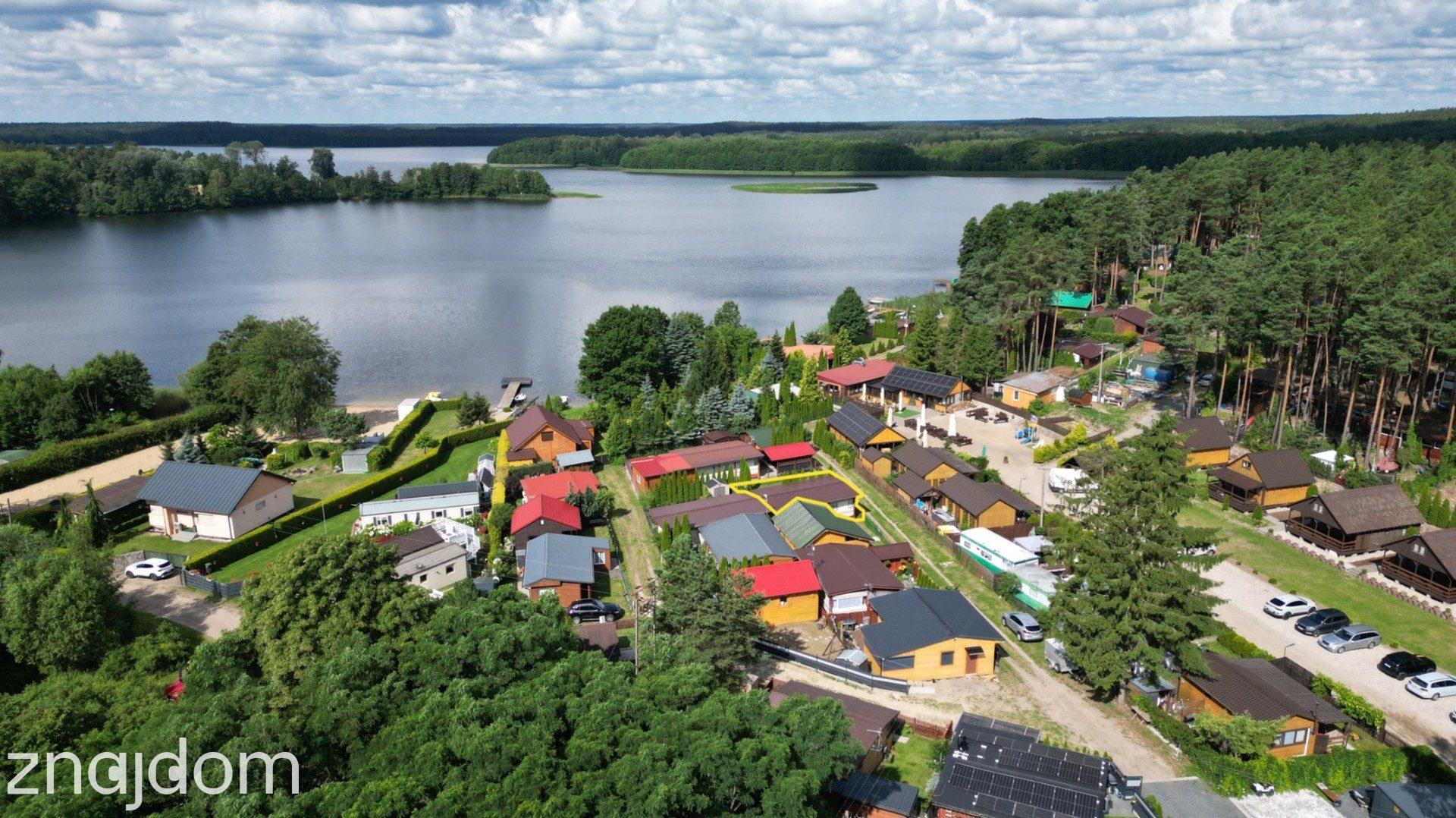 Działka rekreacyjna z domkiem nad jeziorem.
